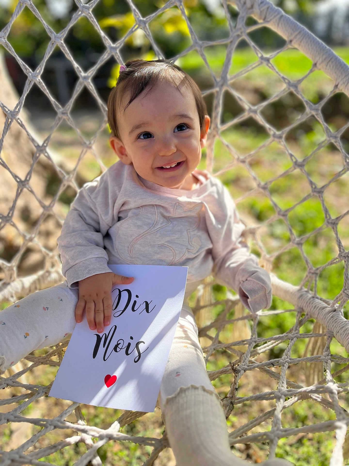 Giulia a rejoint le concours — aidez-le/la à gagner de superbes lots ! baby, child, smiling, outdoor, hammock, chair, sign, sunlight, nature, greenery, portrait, cute, card, clothing, baby_clothes, happy, face, infant, sitting, daylight