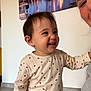 Giulia participe au concours pour gagner de l'argent avec cette photo : toddler, child, smiling, indoor, person, face, happy, painting, wall, clothing, long_sleeve, polka_dot, adult, partial_face, floor, home, joy, expression, casual, portrait