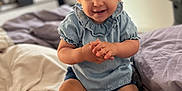 Giulia participe au concours pour gagner de l'argent avec cette photo : toddler, child, baby, smiling, clapping, bed, blue_clothing, shorts, indoor, person, happy, cute, young_child, curly_hair, skin, face, hands, legs, room, cozy