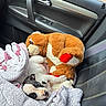 Ruby joined the competition — help win amazing prizes! puppy, dog, stuffed_animal, plush_toy, car, car_seat, blanket, sleeping, lying_down, cuddling, pet, animal, cute, indoor, vehicle, brown_and_white, black_and_white, portrait, cozy, closeup