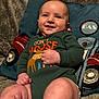 Wyatt joined the competition — help win amazing prizes! baby, smile, green_onesie, moose_graphic, pillow, gas_pump_design, fuzzy_blanket, infant, cute, chubby_legs, happy, indoors, portrait, child, clothing, hand, face, sitting, cozy, warm