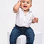 baby, child, smiling, white_shirt, blue_jeans, barefoot, cube, studio, portrait, cute, happy, sitting, toddler, hands, face, clothing, isolated, background, young, boy