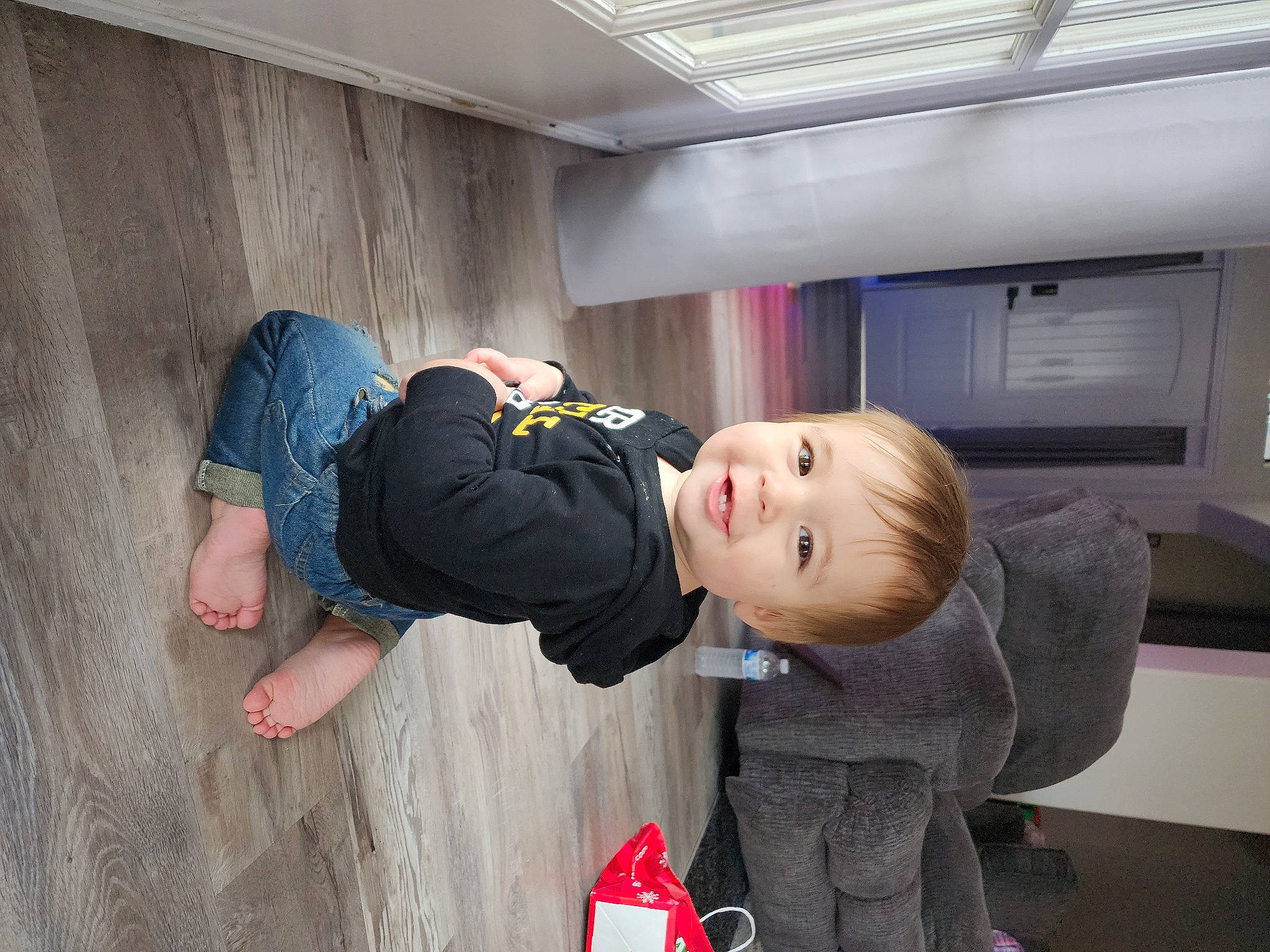 Parker is registered to the contest to win money with this photo: baby, baby_toddler_clothing, child, comfort, floor, flooring, fun, joy, luxury_vehicle, person, play, room, sitting, t_shirt, toddler, wood