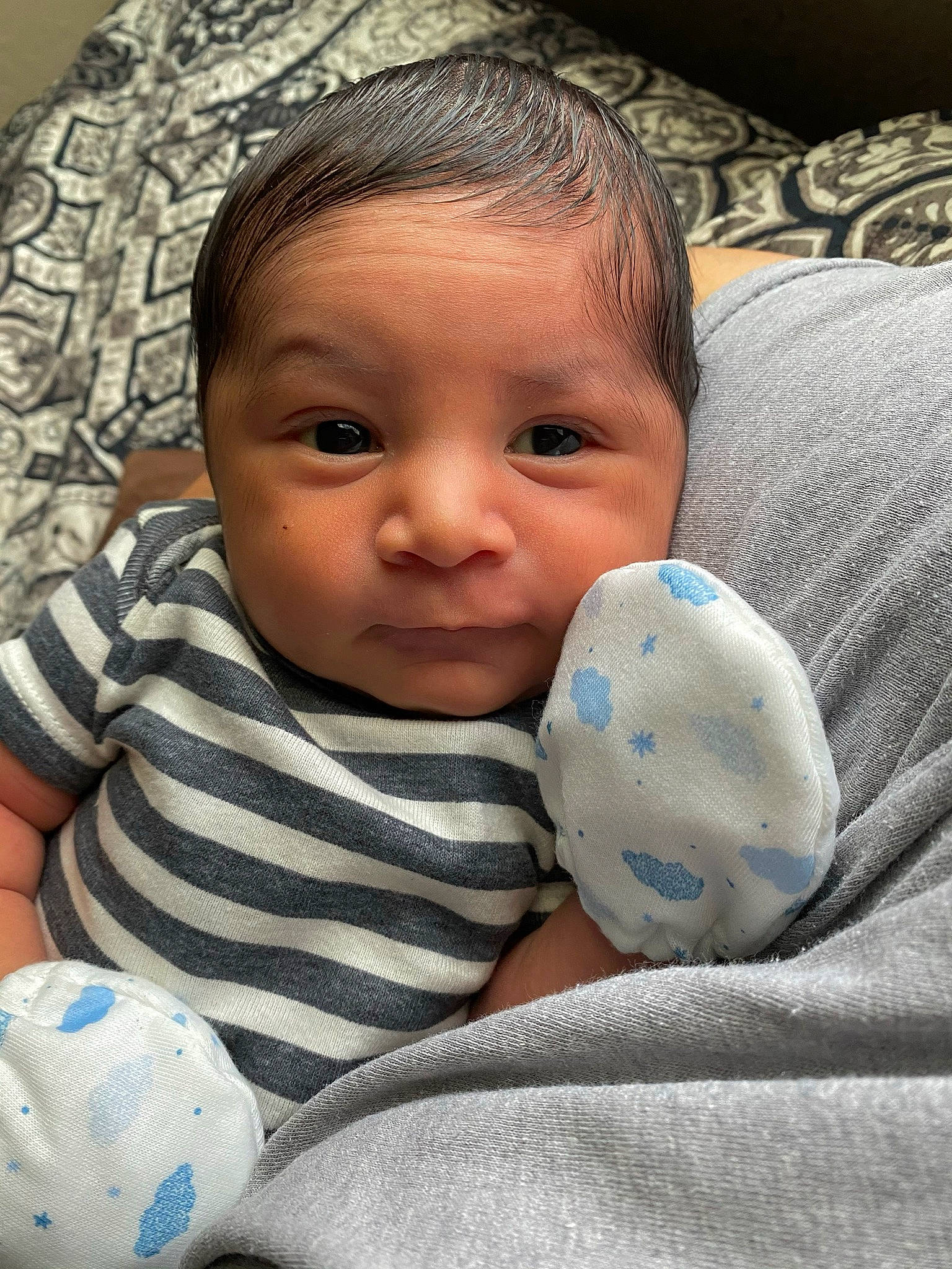 Uriah is registered to the contest to win money with this photo: baby, baby_products, baby_sleeping, baby_toddler_clothing, cheek, child, comfort, finger, fun, happy, head, linens, mouth, nose, pattern, person, room, sitting, skin, thumb