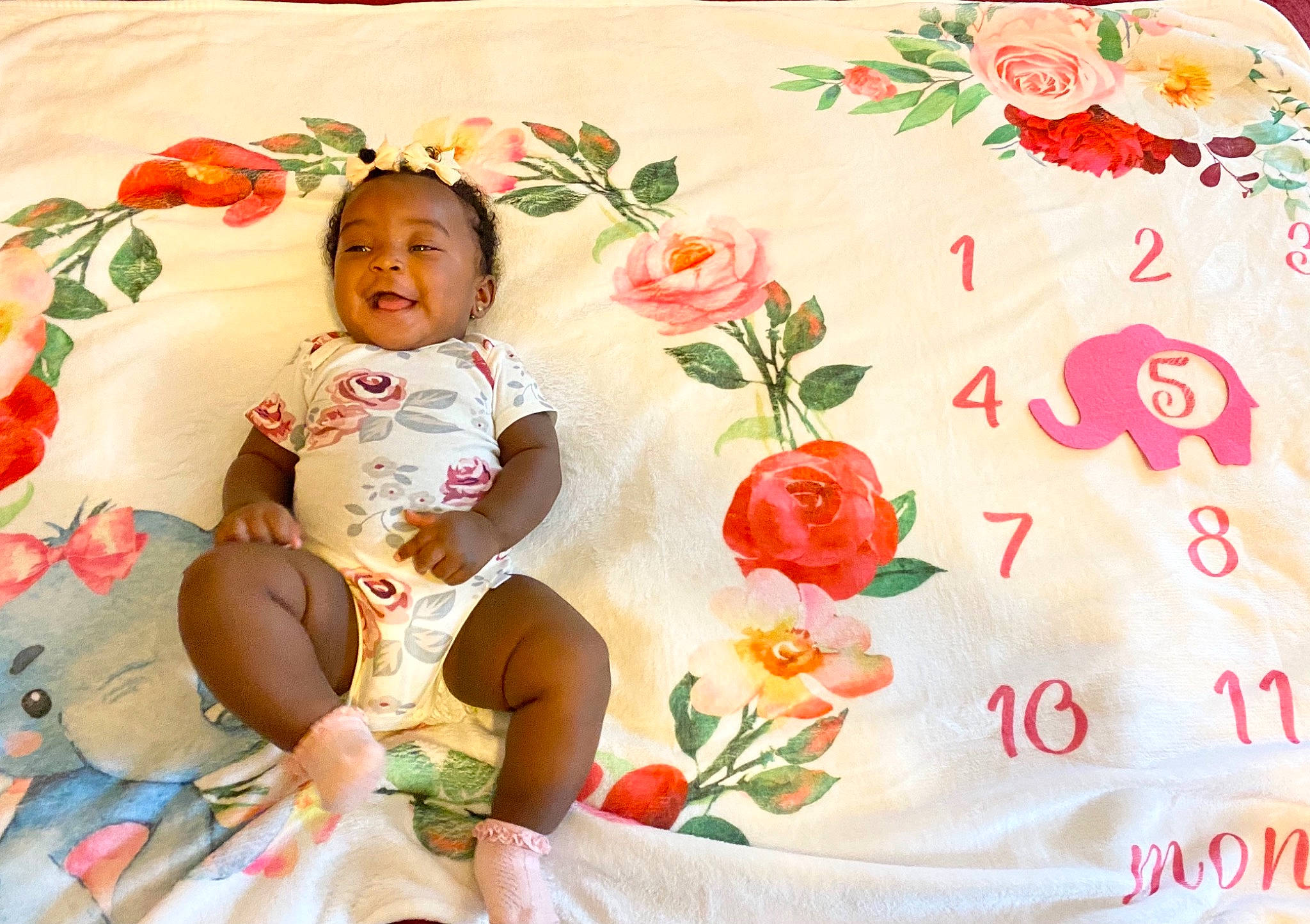 Harleigh is registered to the contest to win money with this photo: baby, baby_sleeping, baby_toddler_clothing, comfort, facial_expression, flower, happy, linens, pattern, people_in_nature, person, petal, pink, plant, product, rose, skin, sleeve, smile, textile