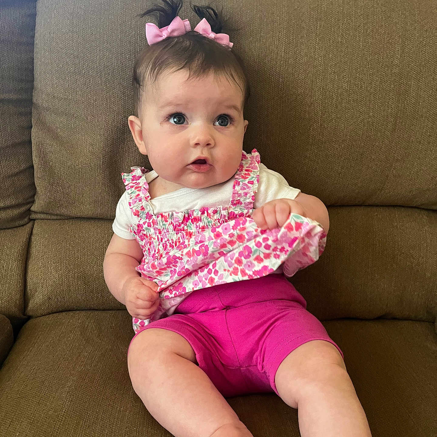 Madelyn joined the competition — help win amazing prizes! baby, casual_clothing, child, couch, curious, cute, floral_top, furniture, home, indoors, infant, pink_bows, pink_shorts, playful, portrait, sitting, small_hands, soft_skin, wide_eyes, young