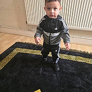Demir joined the competition — help win amazing prizes! toddler, child, indoor, carpet, floor, radiator, tracksuit, adidas, black_clothing, curious_expression, standing, young_child, sporty, casual_wear, wooden_floor, patterned_rug, home_interior, portrait, person, footwear