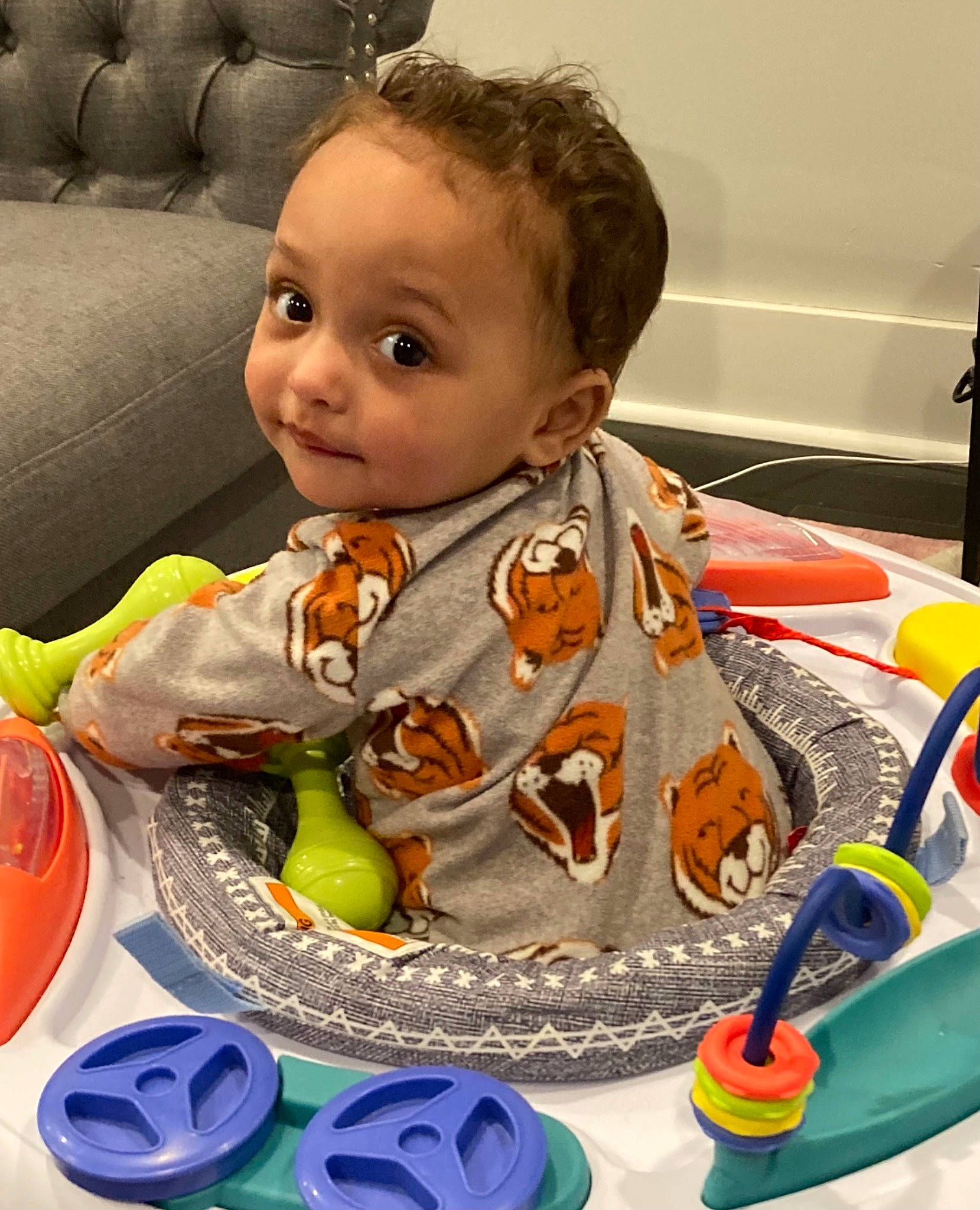 Cameron is registered to the contest to win money with this photo: baby, baby_products, baby_toddler_clothing, cheek, child, comfort, drinkware, fun, iris, mouth, nose, orange, person, personal_protective_equipment, plate, play, sitting, sofa_bed, studio_couch, tableware