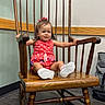 toddler, child, baby, portrait, smiling, sitting, rocking_chair, antique_furniture, wooden_chair, red_outfit, hair_bow, sneakers, indoor, hallway, wood_floor, wall, handrail, furniture, happy, photography