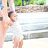 Willow is registered to the contest to win money with this photo: child, toddler, water, splash, adult, holding_hands, outdoor, sunlight, steps, tattoo, denim_shorts, floral_outfit, baby, summer, play, fun, person, skin, legs, daylight