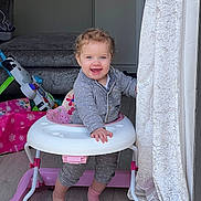 Isabelle joined the competition — help win amazing prizes! baby, walker, smiling, indoor, pajamas, footwear, curtain, floor, toy, child, person, furniture, happy, standing, blue_eyes, hair, hand, face, home, plush