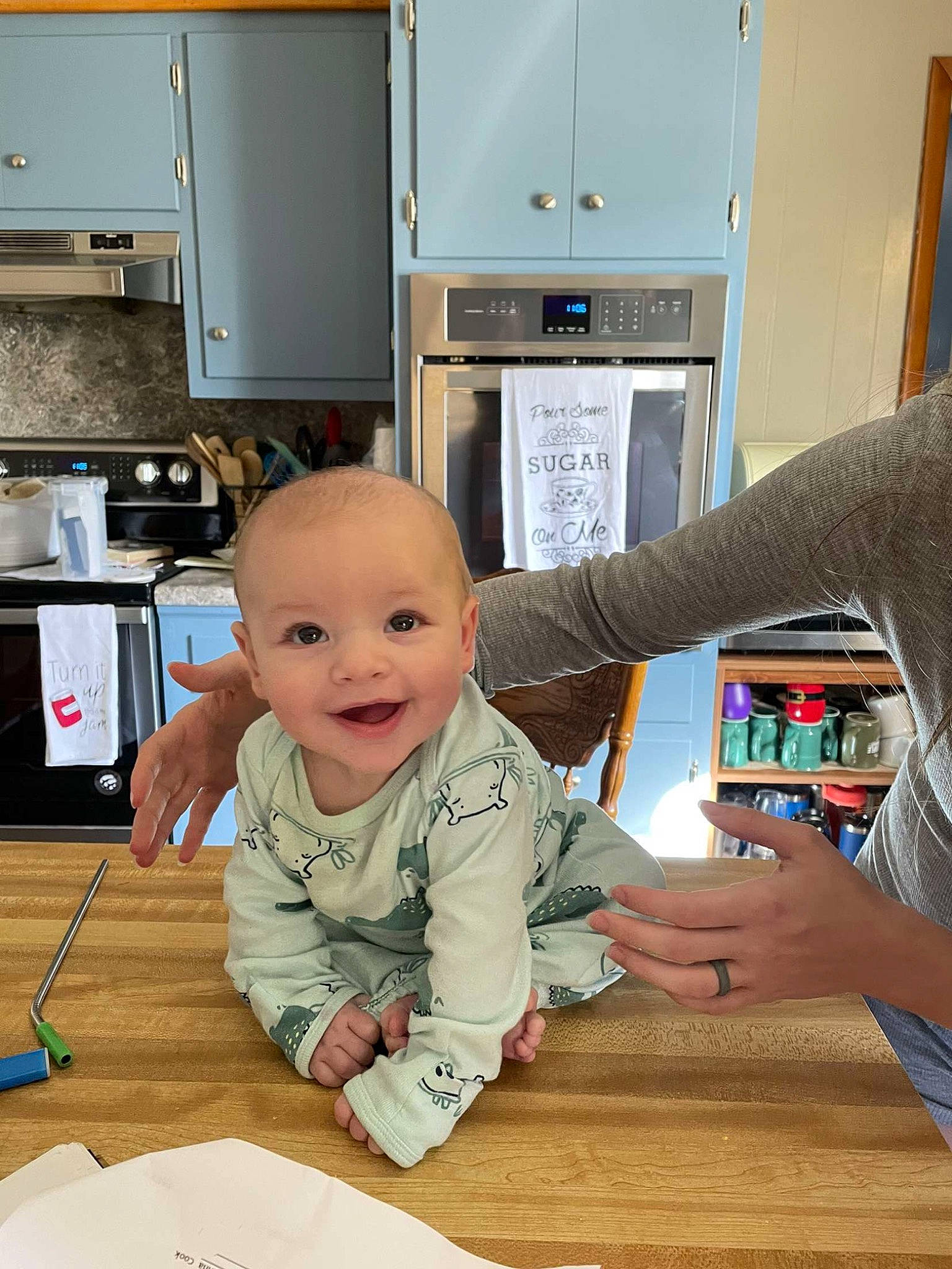 Colter is registered to the contest to win money with this photo: baby, cabinetry, chair, child, desk, electronic_device, finger, floor, flooring, fun, hand, hardwood, joy, machine, person, smile, standing, table, technology, toddler
