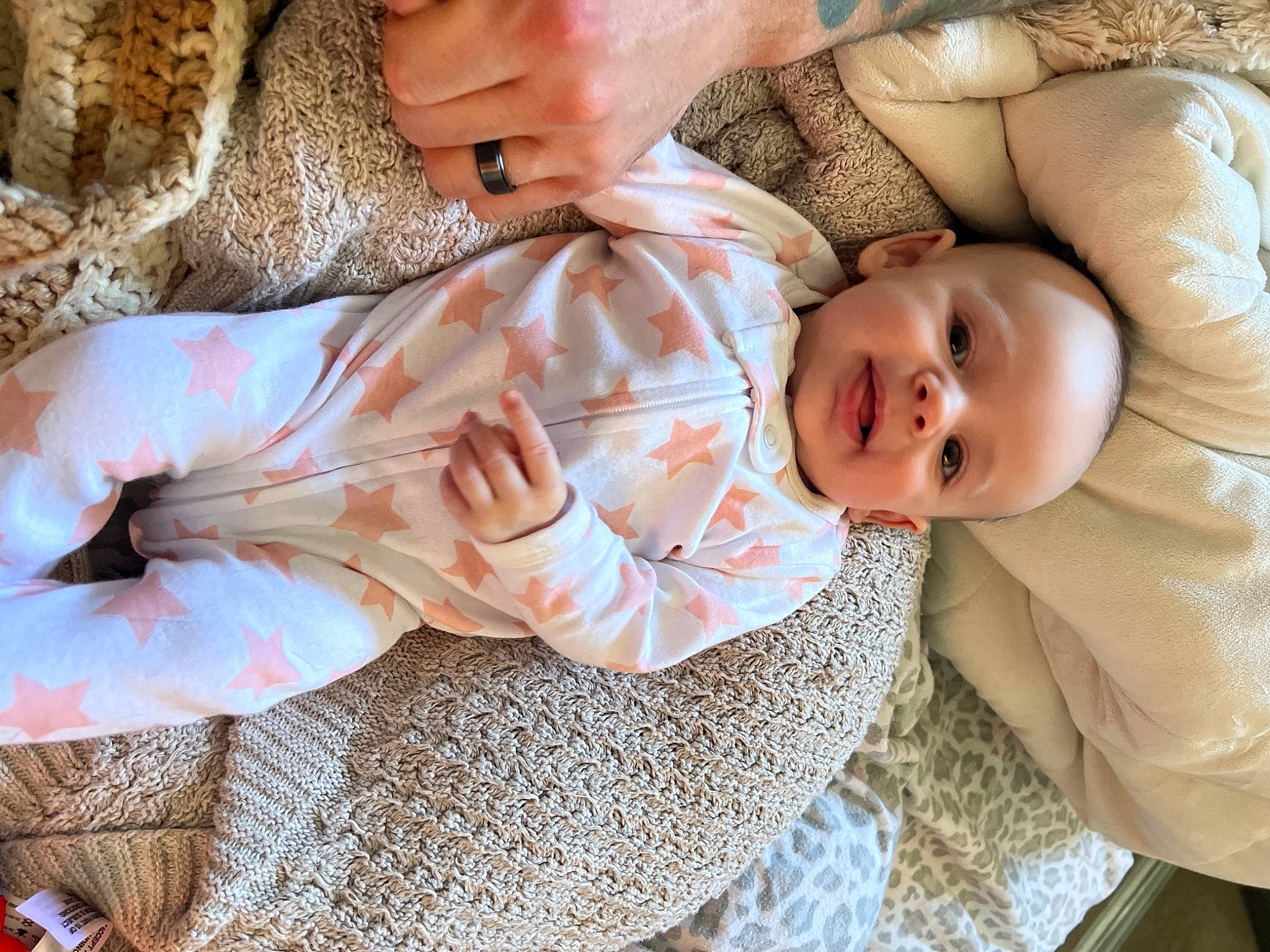 Emelia is registered to the contest to win money with this photo: abdomen, baby, baby_products, baby_toddler_clothing, cheek, child, comfort, couch, finger, hand, happy, head, human_body, linens, pattern, person, skin, sleeve, smile, toddler