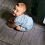 toddler, child, smiling, light_blue_clothing, floor, tile, indoors, person, baby, cute, happy, sitting, looking_up, short_hair, skin, playful, young_child, casual, portrait, natural_light