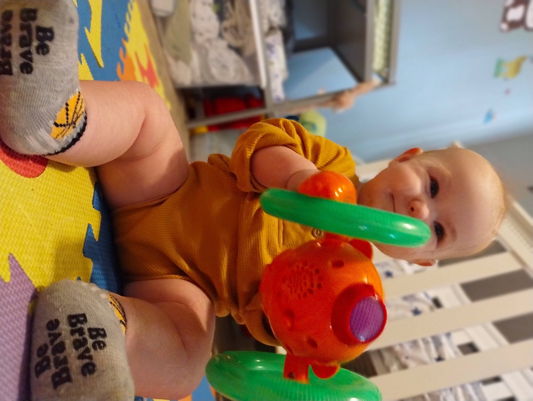 Westin is registered to the contest to win money with this photo: animation, baby, baby_products, baby_safety, baby_toys, child, figurine, flooring, foot, fun, human_leg, orange, person, plastic, play, room, stuffed_toy, toddler, toy, toy_vehicle