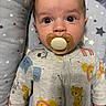 Henry joined the competition — help win amazing prizes! baby, infant, child, portrait, pacifier, wide_eyed, awake, sitting, onesie, clothing, animal_print, lion, bear, cushion, blanket, stars, indoor, close_up, face, safe