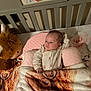 baby, crib, blanket, plush_toy, stuffed_animal, bull, pillow, sleepwear, infant, bed, soft_toys, comfort, cute, child, indoors, resting, person, fabric, cute_baby, sleeping_area