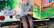 Blaise joined the competition — help win amazing prizes! child, boy, smiling, outdoor, truck, colorful, license_plate, step, grass, casual_clothing, footwear, sunny, happy, young, vehicle, nature, seat, metal, parked, daytime