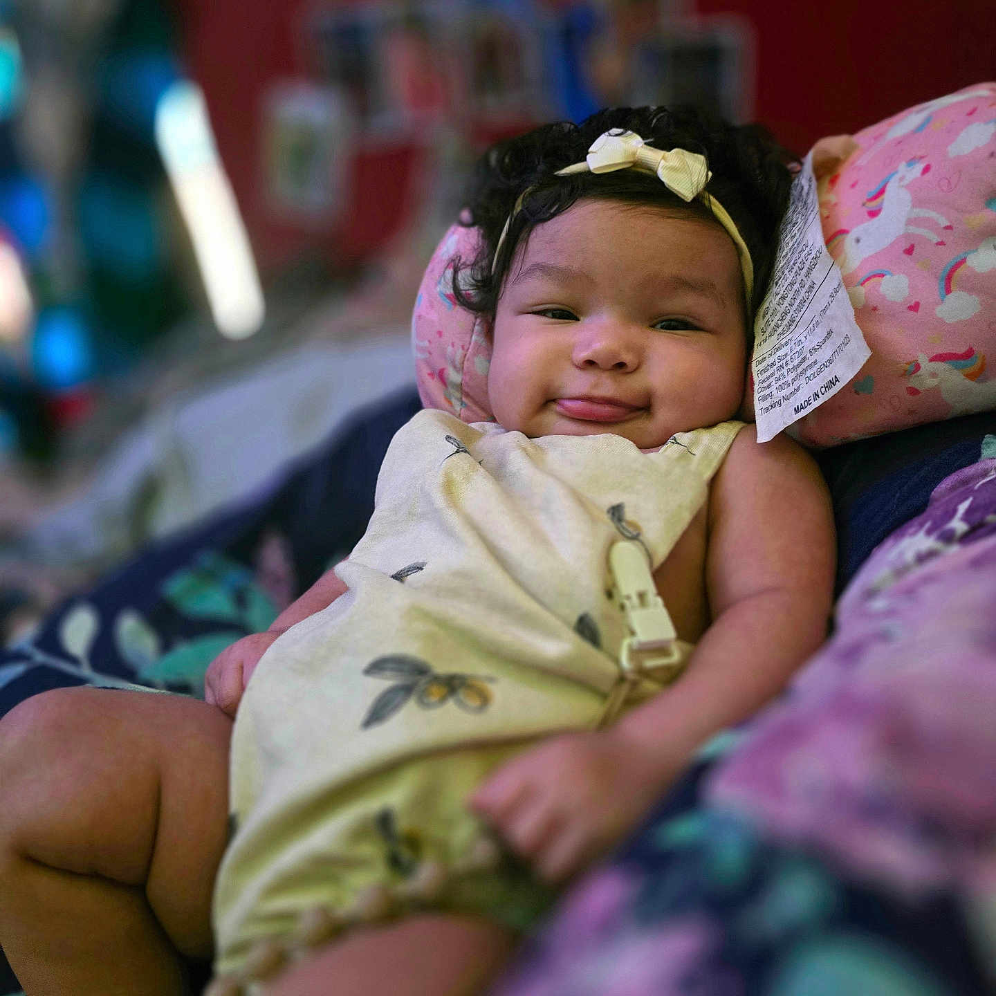 Braslin is registered to the contest to win money with this photo: baby, bed, child, chubby_cheeks, colorful, comfort, cozy, cute, happy, headband, indoor, infant, onesie, person, pillow, portrait, relaxed, smile, soft_fabric, young