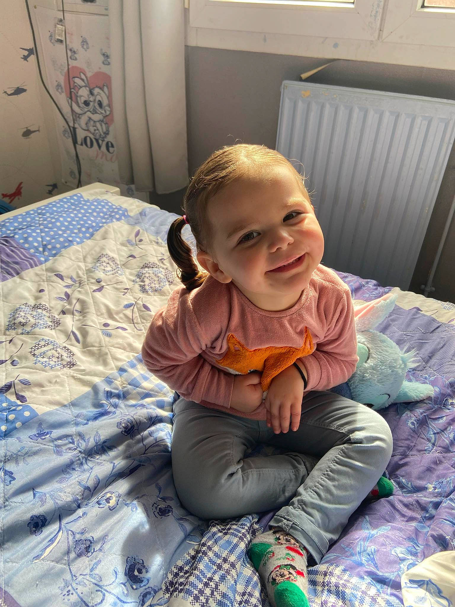 Maëlia participe au concours pour gagner de l'argent avec cette photo : baby, baby_toddler_clothing, child, comfort, eye, flooring, fun, happy, head, joy, leisure, linens, pattern, person, play, purple, room, sitting, smile, toddler