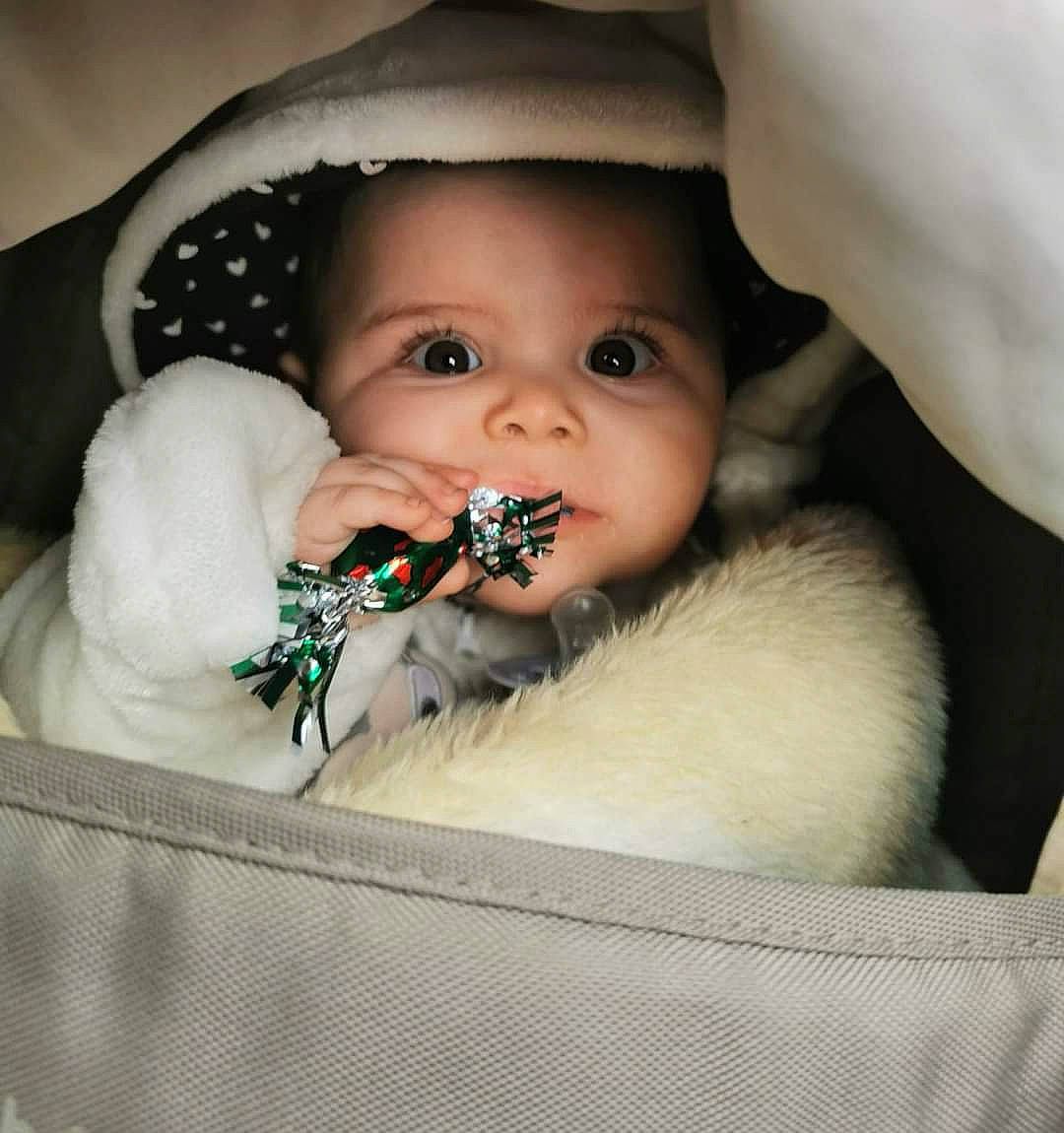 Maëlia participe au concours pour gagner de l'argent avec cette photo : arm, baby, baby_toddler_clothing, cheek, comfort, dress, eye, eyebrow, eyelash, face, hair, hand, head, headgear, human_body, iris, lip, mouth, nose, person