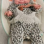 Romane a rejoint le concours — aidez-le/la à gagner de superbes lots ! baby, infant, smiling, leopard_print, onesie, tutu, baby_rocker, cushion, pattern, soft_toy, indoor, child, cute, happy, face, person, clothing, seat, playful, comfort