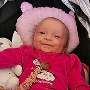 Romane participe au concours pour gagner de l'argent avec cette photo : baby, smiling, pink_clothing, unicorn, plush_toy, pillow, infant, cute, happy, soft_texture, indoor, child, lying_down, face, head, person, clothing, toy, comfort, baby_accessory