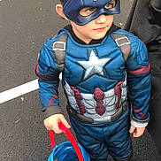 James is registered to the contest to win money with this photo: asphalt, blue, boots, boy, bucket, captain_america, car, child, costume, cute, halloween, holiday, holiday_costume, mask, outdoor, parking_lot, person, superhero, trick_or_treat, young
