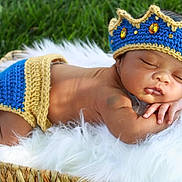 Kaysen is registered to the contest to win money with this photo: baby, sleeping, crown, crocheted, blue, yellow, blanket, basket, grass, outdoor, newborn, infant, resting, cute, soft_texture, portrait, peaceful, headwear, hand, skin