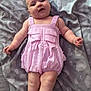 arms_out, baby, blanket, child, chubby, cute, face, gray_blanket, head, indoors, infant, legs_crossed, lying_down, patterned_blanket, pink_romper, portrait, skin, smiling, soft_lighting, striped_clothing