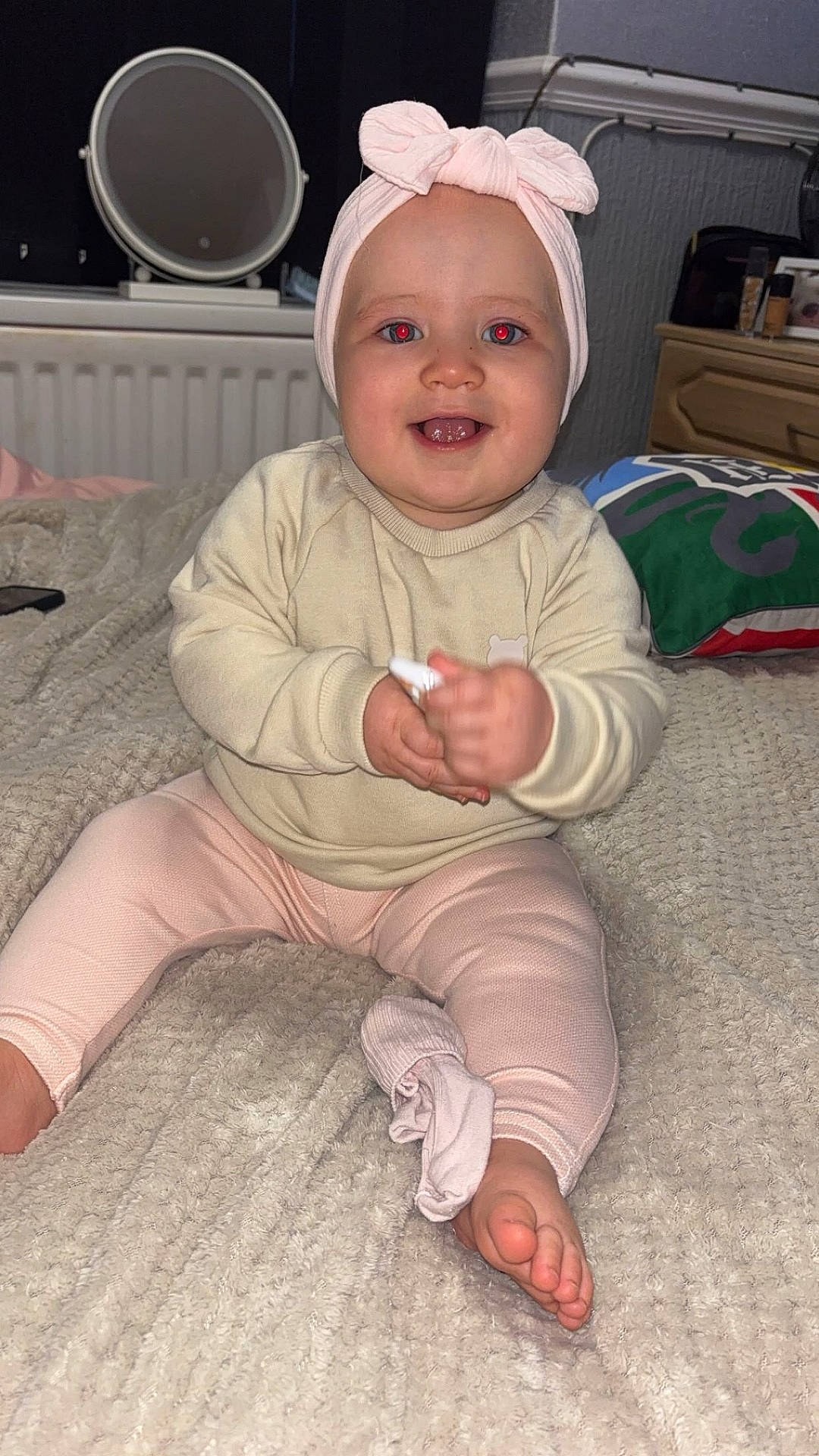 Darcie is registered to the contest to win money with this photo: baby, barefoot, bedroom, blanket, bow, child, cream, cute, furniture, happy, headband, indoor, infant, leggings, mirror, person, pillow, pink, smiling, sweater