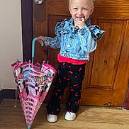 Gabriella joined the competition — help win amazing prizes! toddler, child, blonde_hair, pigtails, denim_jacket, umbrella, minnie_mouse, cherry_pattern, black_pants, white_shoes, wooden_door, wood_floor, indoor, smiling, cute, playful, standing, fashion, person, happy