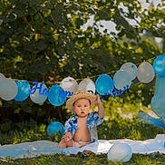 Kalahani participe au concours pour gagner de l'argent avec cette photo : baby, boy, birthday, balloons, straw_hat, blue_shirt, blanket, outdoor, grass, greenery, celebration, number_one_balloon, sunlight, child, happy_birthday_banner, party, nature, summer, cute, portrait