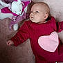 baby, infant, plush_toy, bunny, blanket, pink, red_clothing, heart_patch, lying_down, carpet, cute, looking_up, onesie, soft_toy, newborn, portrait, fabric_texture, cozy, hand, eyes