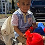 child, boy, outdoor, toy, plush, bench, clothing, shirt, pants, jacket, daytime, car, tree, smile, person, playtime, casual, sunlight, expression, park