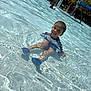 child, pool, water, smiling, sitting, sunlight, swimsuit, water_shoes, play, outdoor, summer, fun, happy, recreation, kid, shallow_water, splash, sunny, leisure, park