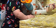 Raelyn is registered to the contest to win money with this photo: brown_hair, carpet, chair, child, clothing, cup, curly_hair, drawing, focus, indoor, leaning, long_sleeve, marker, play, shorts, standing, straw, toddler, toy, yellow_chair