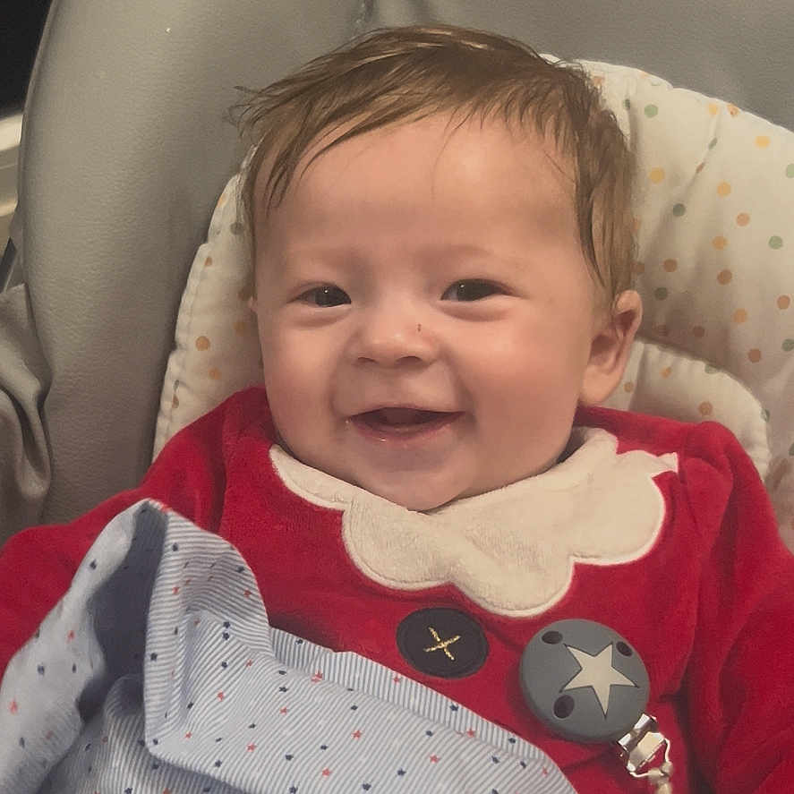 Klemen participe au concours pour gagner de l'argent avec cette photo : baby, baby_bottle, blanket, bottle, child, clothing, cozy, cute, face, happy, head, indoors, infant, pacifier_clip, person, portrait, red_outfit, seat, smiling, warm