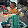 Jayden joined the competition — help win amazing prizes! toddler, baby_walker, orange_shirt, toy, indoor, carpet, couch, living_room, child, person, furniture, curly_hair, play, seat, home, floor, plastic, window, colorful, young_child