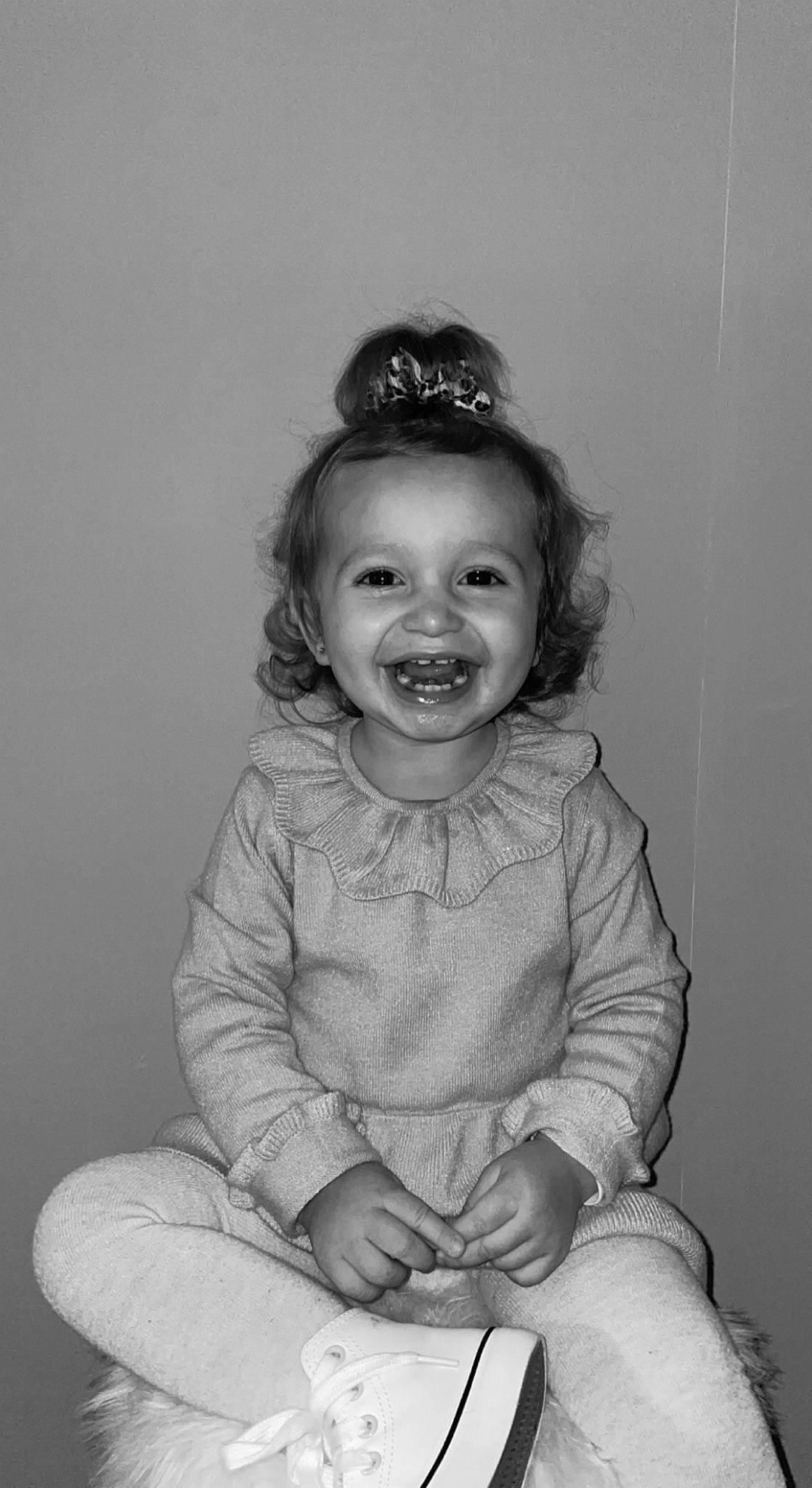 Myla a rejoint le concours — aidez-le/la à gagner de superbes lots ! baby, baby_toddler_clothing, black, black_and_white, cheek, eye, face, flash_photography, gesture, hair, happy, head, headgear, iris, joy, person, sleeve, smile, standing, style