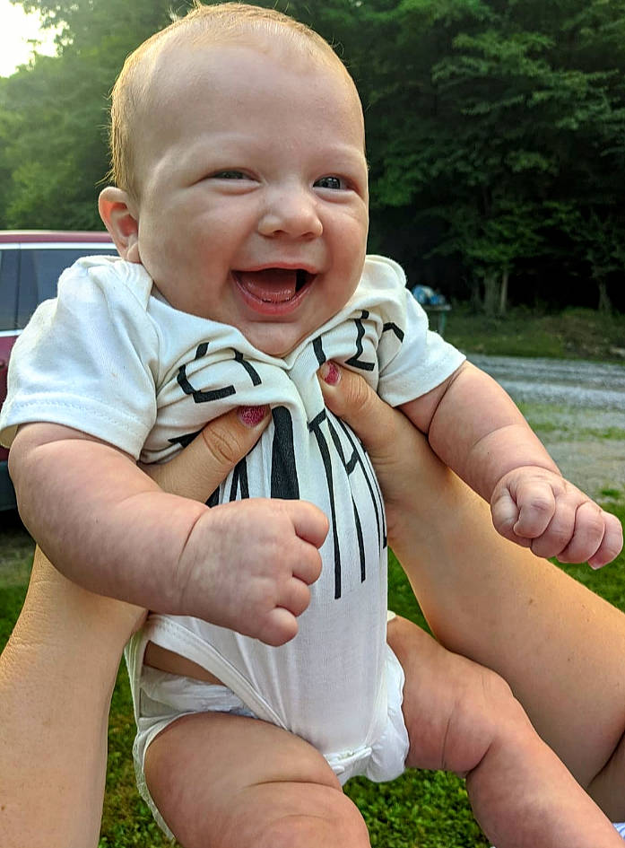 Logan Ezra joined the competition — help win amazing prizes! baby, baby_toddler_clothing, blond, child, cool, finger, fun, gesture, grass, happy, leisure, people_in_nature, person, plant, sitting, skin, smile, thigh, thumb, toddler