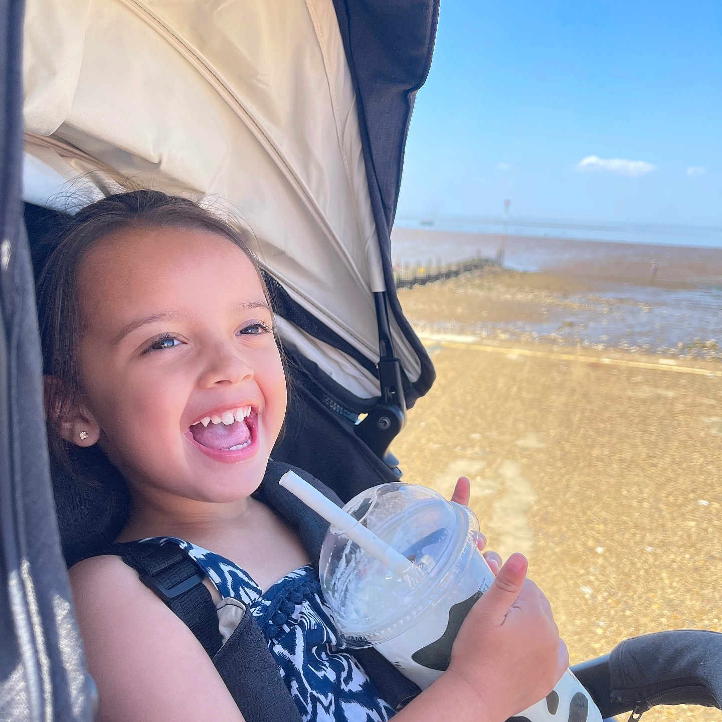 Amber Rae joined the competition — help win amazing prizes! beach, child, clothing, cup, daylight, drink, fun, happy, outdoor, person, portrait, relaxation, seatbelt, sky, smiling, straw, stroller, summer, sunny, vacation