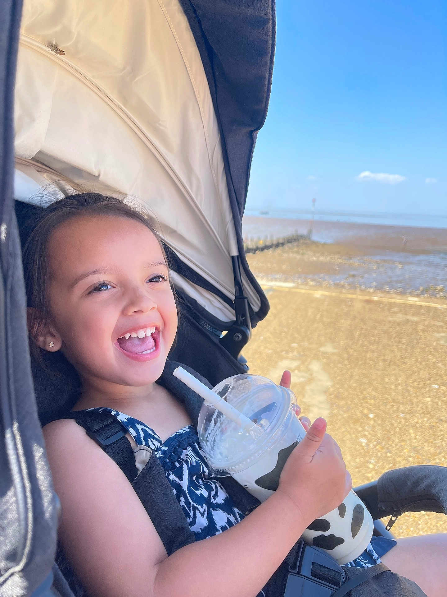 Amber Rae joined the competition — help win amazing prizes! beach, child, clothing, cup, daylight, drink, fun, happy, outdoor, person, portrait, relaxation, seatbelt, sky, smiling, straw, stroller, summer, sunny, vacation