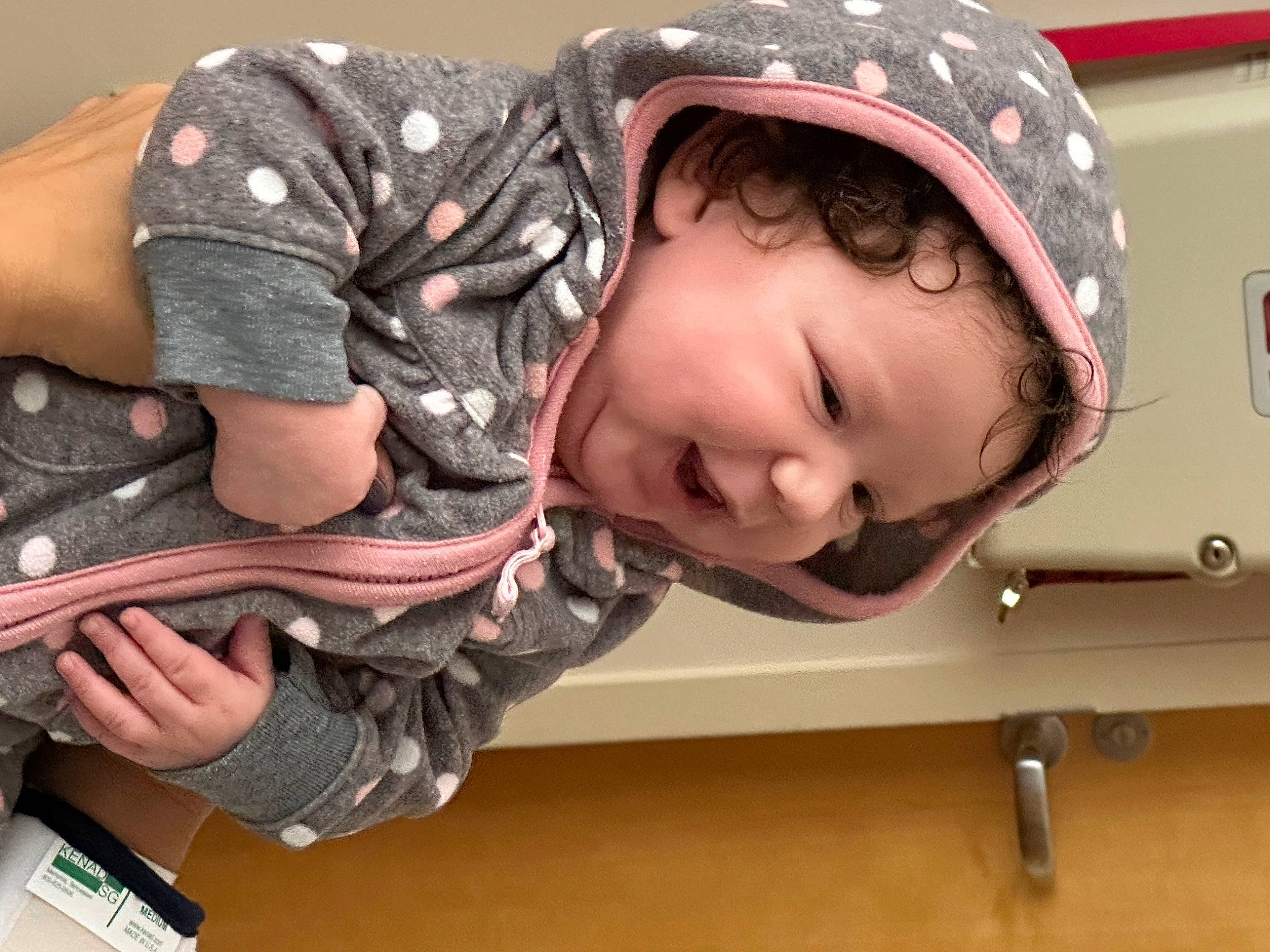 Khelani is registered to the contest to win money with this photo: bangs, cap, child, fashion_accessory, fun, happy, headgear, helmet, magenta, pattern, person, personal_protective_equipment, portrait_photography, sitting, sleeve, smile, toddler, tree, wood