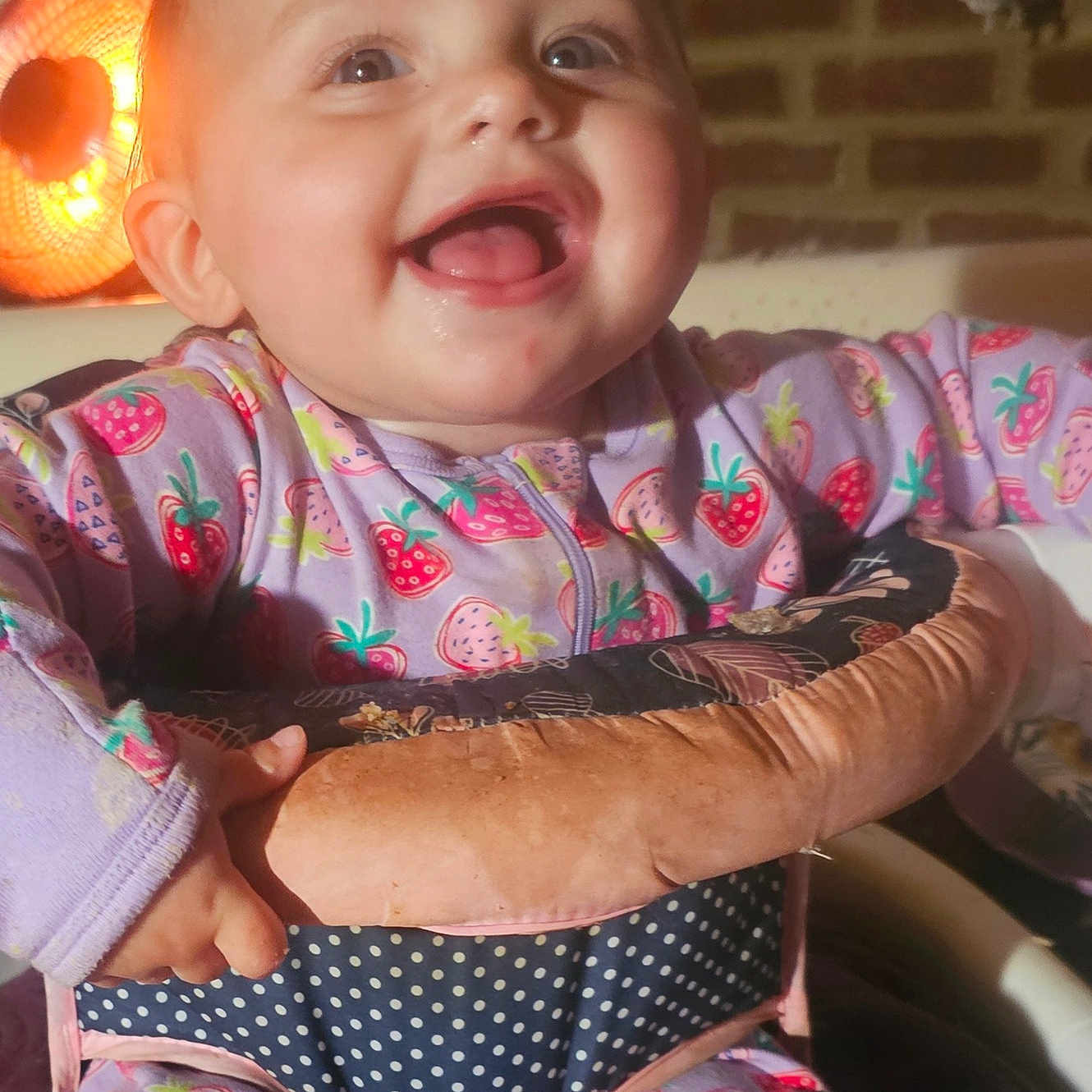 Laniey joined the competition — help win amazing prizes! baby, brick_wall, child, clothing, cozy, cute, expression, face, hand, happy, home, indoor, infant, pajamas, polka_dots, portrait, seat, smiling, strawberry_pattern, warm_light