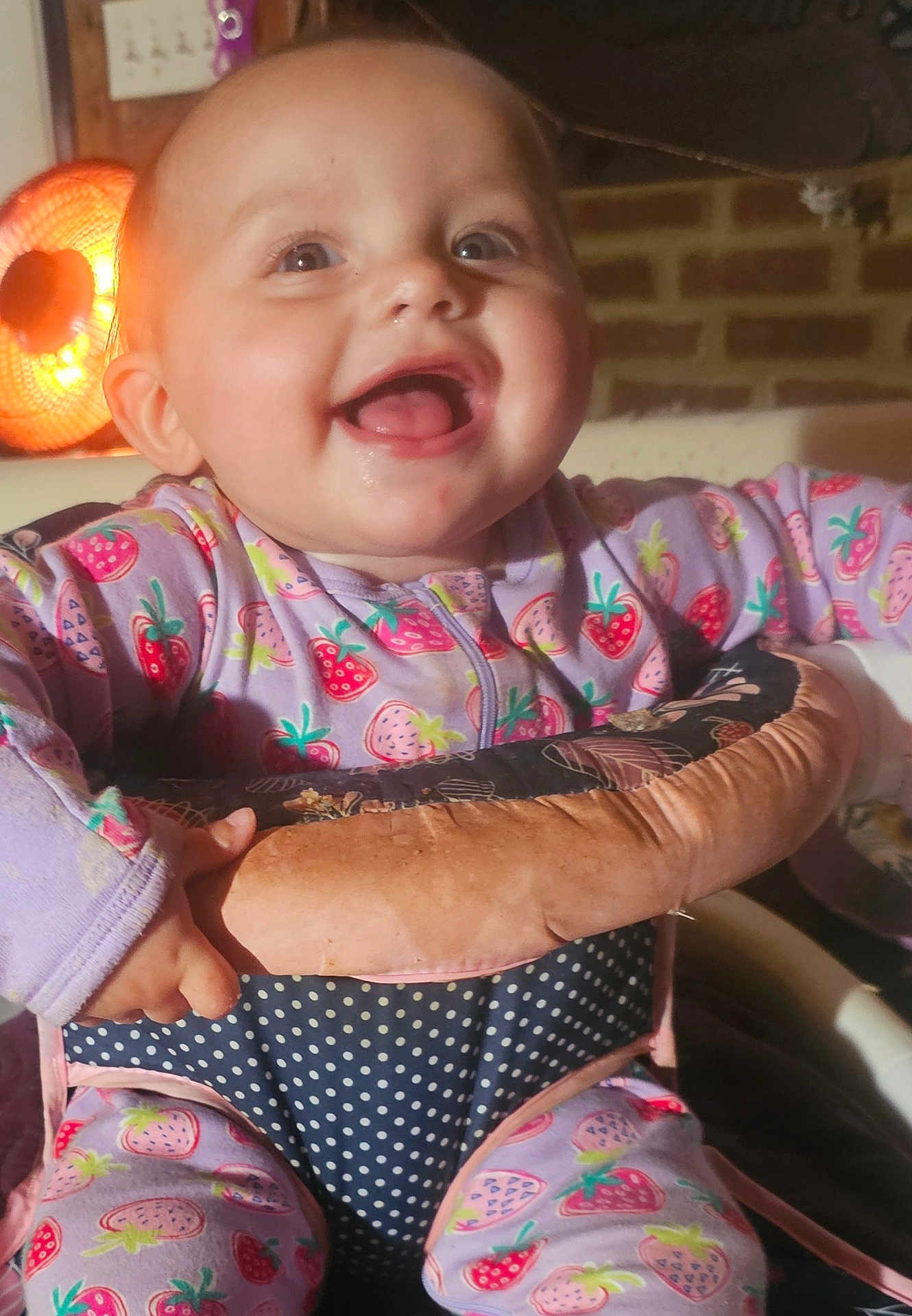 Laniey joined the competition — help win amazing prizes! baby, child, smiling, pajamas, strawberry_pattern, polka_dots, seat, indoor, happy, face, expression, hand, clothing, warm_light, brick_wall, cute, infant, portrait, cozy, home