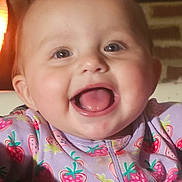 Laniey joined the competition — help win amazing prizes! baby, smiling, happy, child, face, tongue, clothing, purple, strawberry_pattern, infant, cute, portrait, indoor, warm_light, head, young_child, expression, joyful, sitting, person