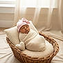 Hannah is registered to the contest to win money with this photo: newborn, baby, sleeping, basket, knitted_wrap, pillow, heart_shaped_cushion, pink_hat, bow, cozy, indoors, soft_light, curtains, resting, cute, infant, portrait, peaceful, warm, woven