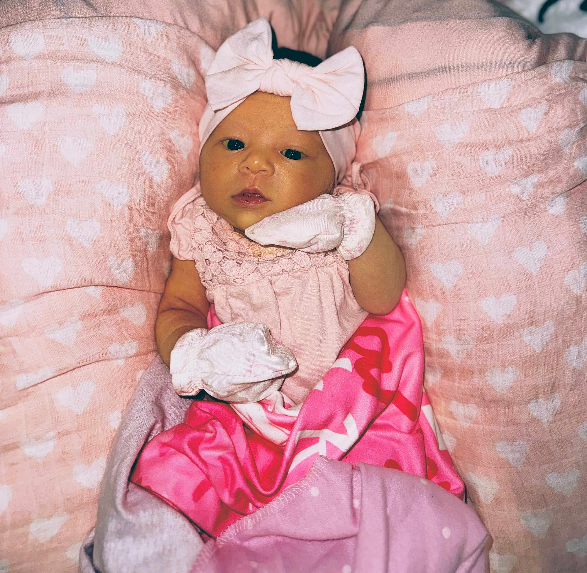 Hannah is registered to the contest to win money with this photo: baby, infant, pink, blanket, mittens, headband, bow, heart_pattern, cushion, soft, cute, newborn, clothing, portrait, wrapped, sleepy, resting, indoor, child, adorable