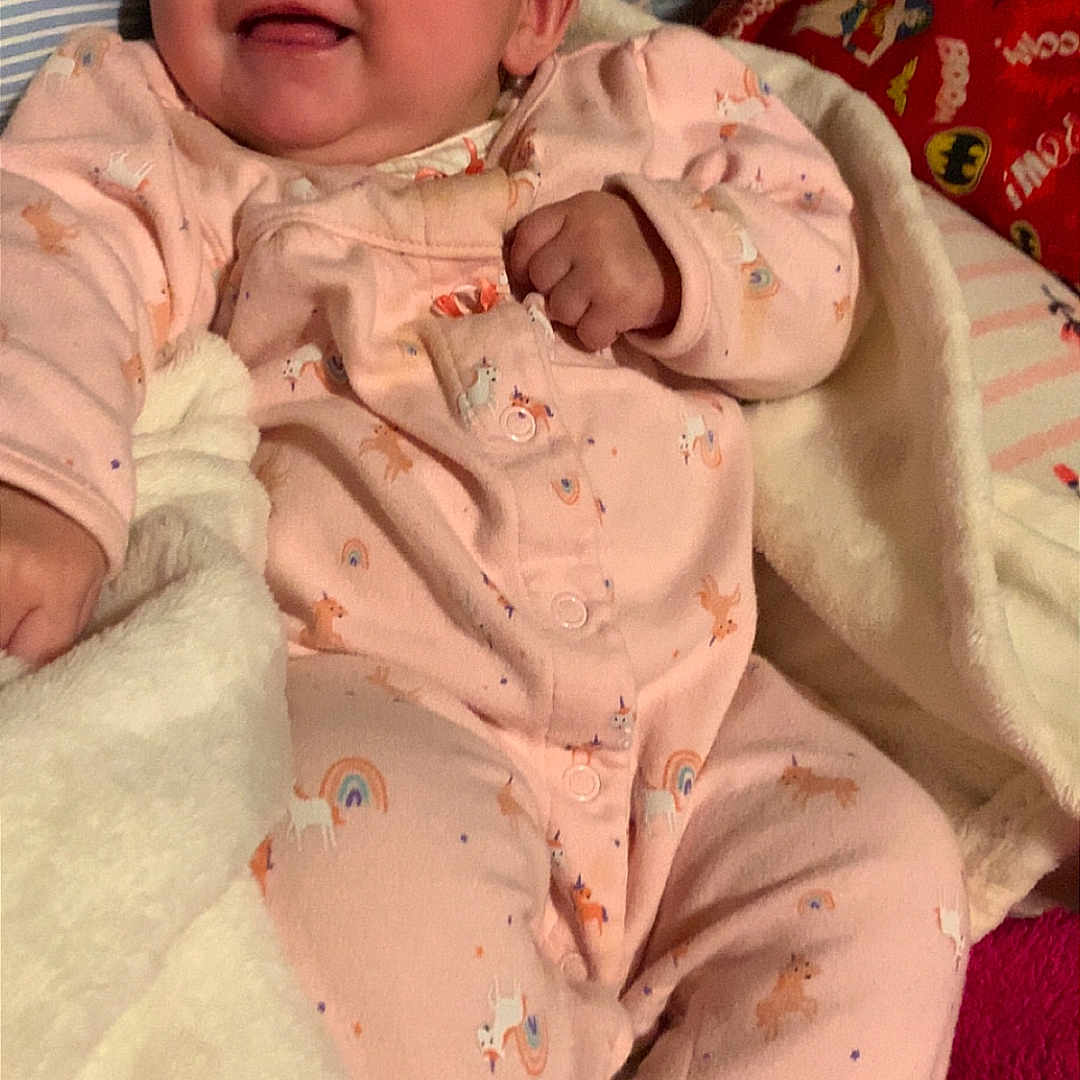 Mercedes joined the competition — help win amazing prizes! baby, bed, blanket, child, comfort, cozy, cute, face, footwear, happy, indoors, infant, pajamas, person, rainbow, sleepwear, smiling, soft, unicorn, warm